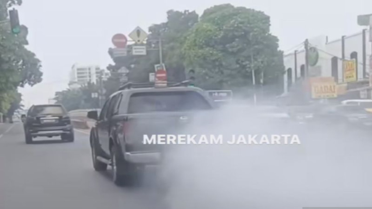Mobil pelat merah, kendaraan operasional Suku Dinas Tenaga Kerja dan Transmigrasi Jakarta Pusat mengeluarkan asap tebal saat melaju di Jalan Mampang Prapatan, Jakarta Selatan, Minggu (10/9/2023) pukul 10.56 WIB. (ANTARA/Ho/Instagram @merekamjejak)