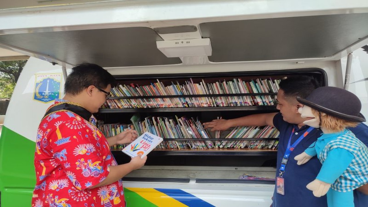 Duta baca dan petugas perpustakaan keliling menata buku di mobil operasional. (ANTARA/Rina Nur Anggraini)
