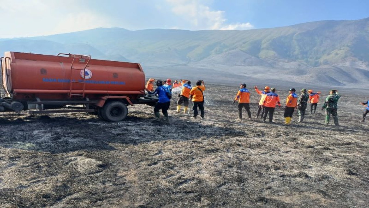 Petugas gabungan melakukan pendinginan dengan menggunakan truk tangki air untuk menyiram bekas karhutla di kawasan Gunung Bromo, Kabupaten Probolinggo, Senin (11/9/2023). (ANTARA/HO-BPBD Probolinggo)