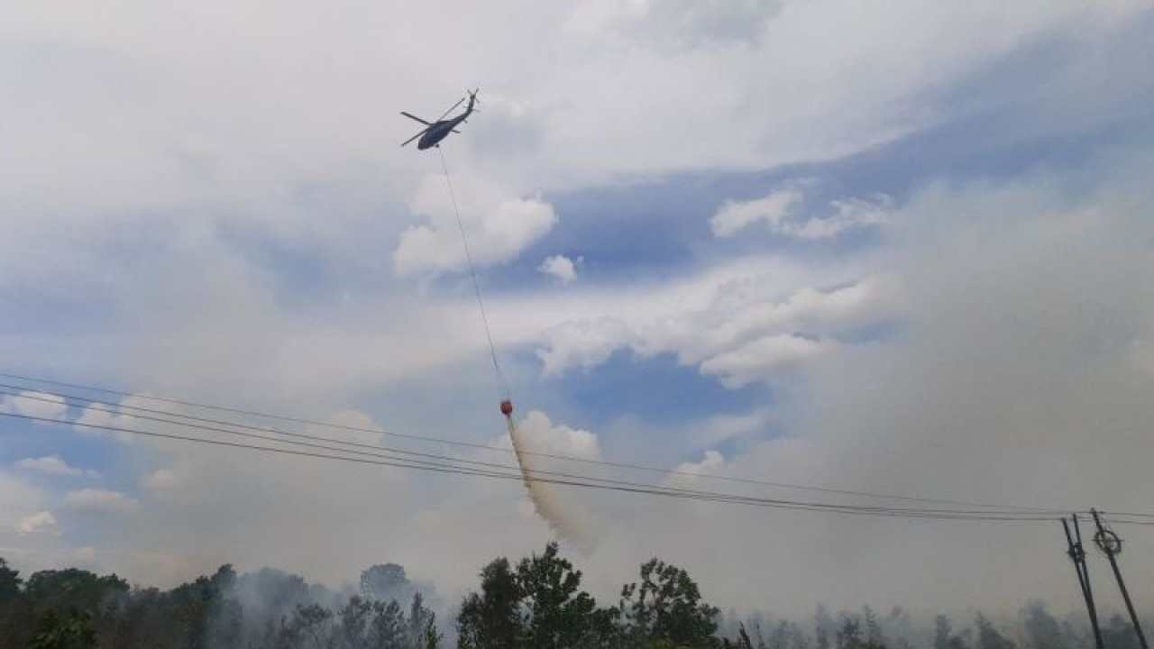 Helikopter water boombing melakukan pemadaman lahan terbakar di sekitar kawasan yang tak jauh dari Bandara Internasional Syamsudin Noor di Banjarbaru. (ANTARA/Firman)