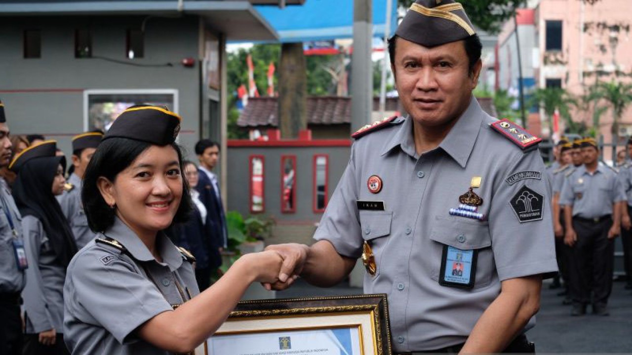 Kakanwil Kemenkumham Sumut Imam Suyudi ( kanan) saat menyerahkan penghargaan Pegawai Teladan Bulan Agustus 2023 kepada Kristina Agustiani Sianturi ( kanan). (ANTARA/HO- Humas Kemenkumham Sumut).