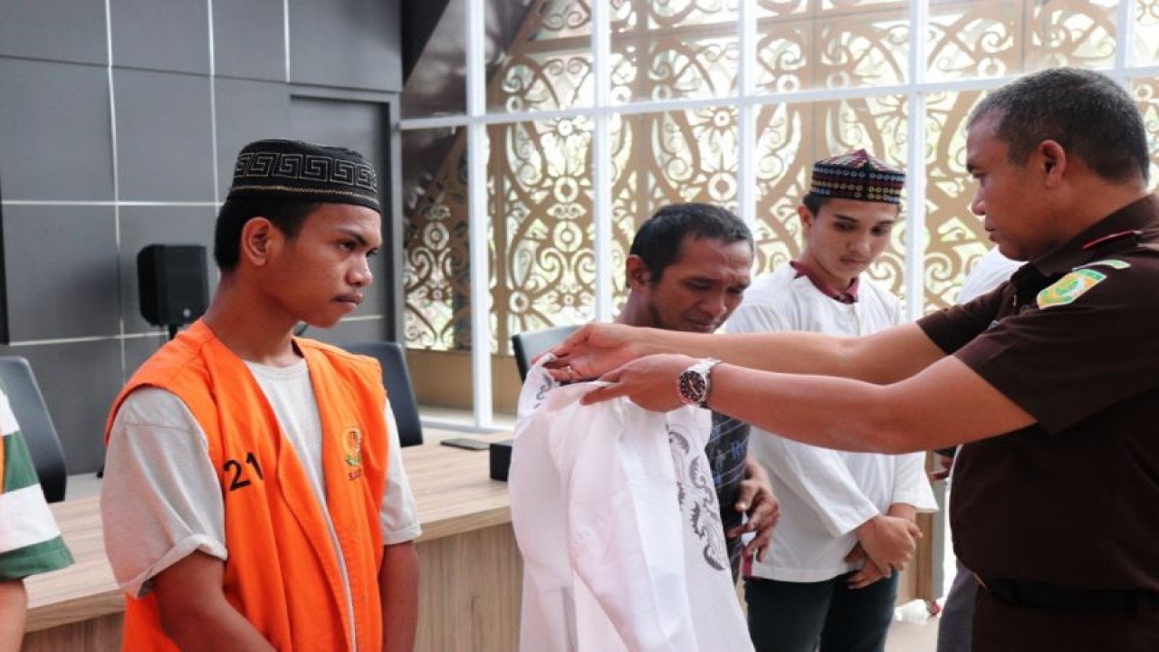 Kajari Samarinda Firmansyah Subhan melepaskan rompi narapidana sekaligus memakaikan baju biasa kepada mantan tersangka yang bebas berdasarkan rostorative justice, di Samarinda, Selasa (5/9/2023). (ANTARA /HO-Kasi Intel Kejari Samarinda.
