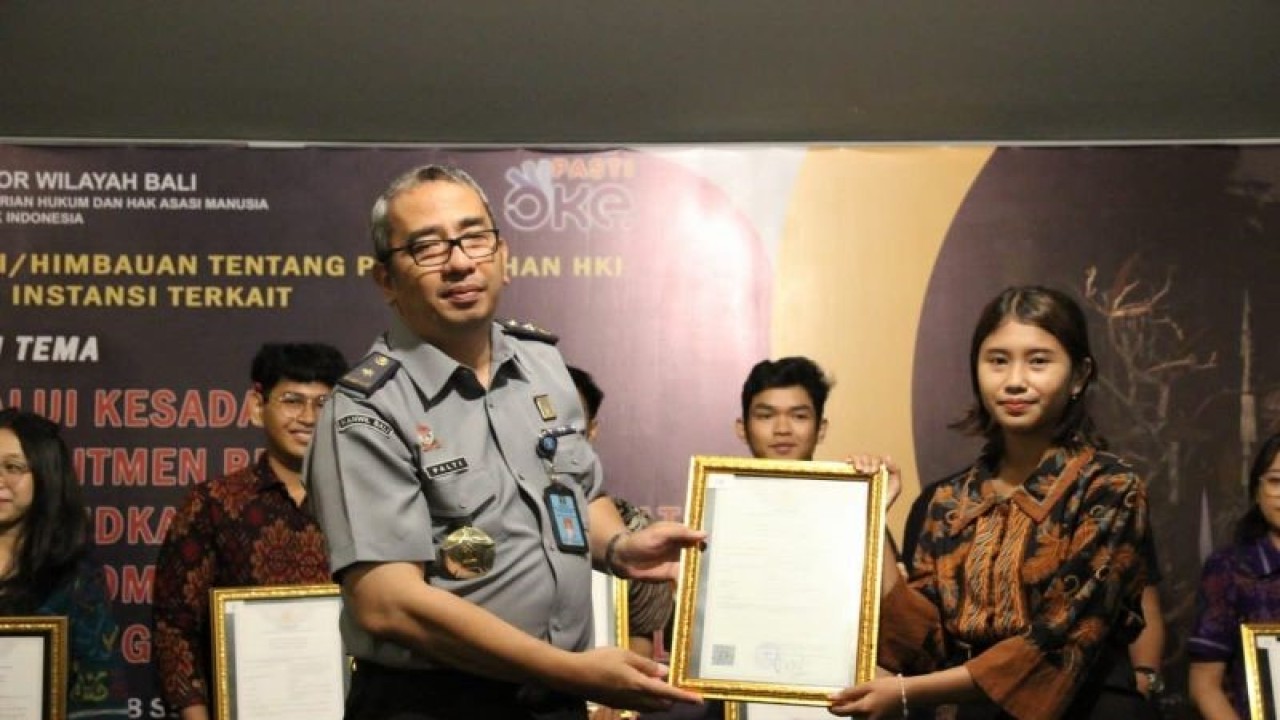 Kepala Divisi Pelayanan Hukum dan HAM Kanwil Kemenkumham Bali Alexander Palti (kiri) menyerahkan sertifikat pencatatan kekayaan intelektual komunal di Denpasar, Senin (18/9/2023) ANTARA/HO-Kemenkumham Bali