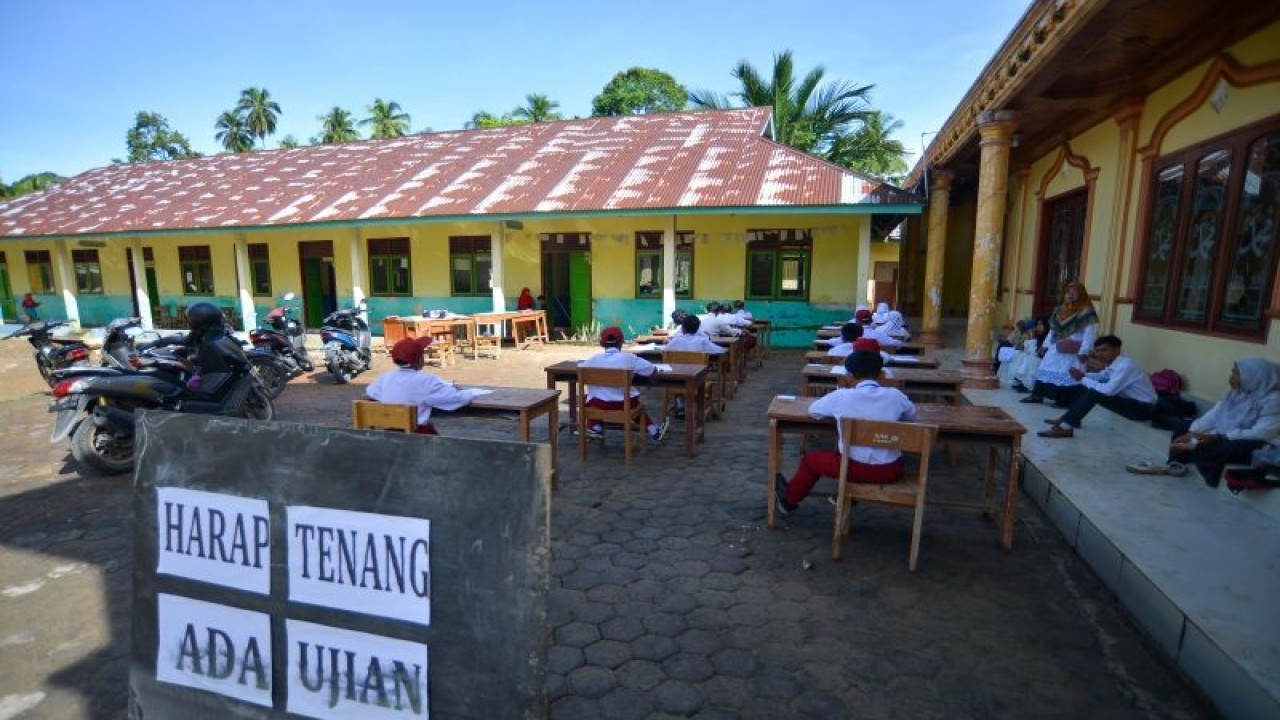 Arsip Foto - Siswa mengerjakan soal ujian di halaman Madrasah Ibtidaiyah Swasta (MIS) Tanjung Medan, Ulakan Tapakis, Padang Pariaman, Sumatera Barat, Senin (8/5/2023). (ANTARA FOTO/Iggoy el Fitra)