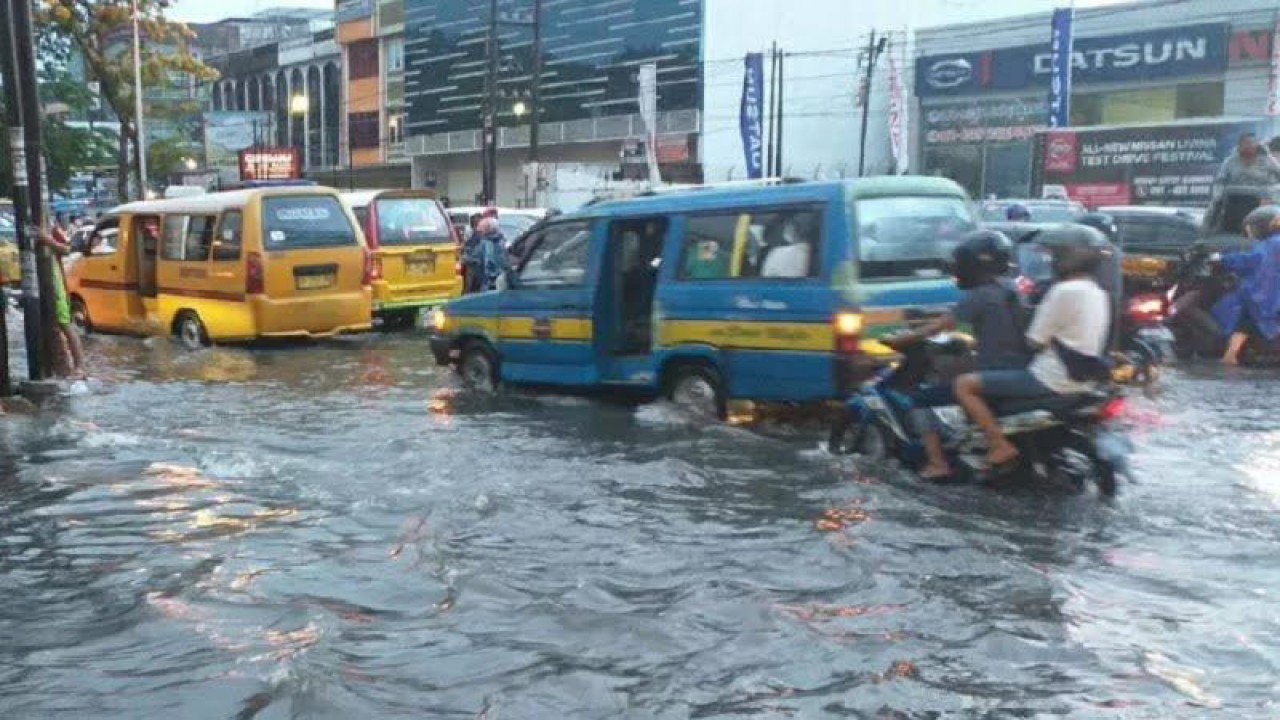 Sejumlah angkutan kota melintasi ruas jalan yang dilanda genangan air akibat hujan lebat di Medan, Sumut, Rabu (19/6/2019). ANTARA/HO-Dokumentasi pribadi