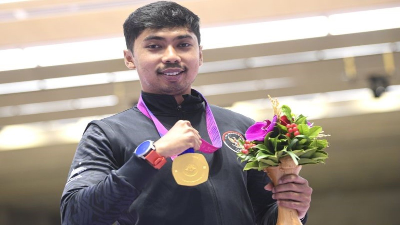Petembak tunggal putra Indonesia Muhammad Sejahtera Dwi Putra berpose dengan medali emasnya usai upacara penghargaan pemenang final 10 meter running target Asian Games 2022 di Fuyang Yinhu Sports Centre, Hangzhou, China, Senin (25/9/2023). . ANTARA FOTO/M Risyal Hidayat/aww