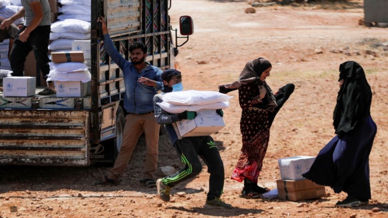 Foto Arsip - Seorang pekerja memegang tas dan sekotak bantuan kemanusiaan di Idlib yang dikuasai oposisi di Suriah 9 Juni 2021. ANTARAéREUTERS/Khalil Ashawi