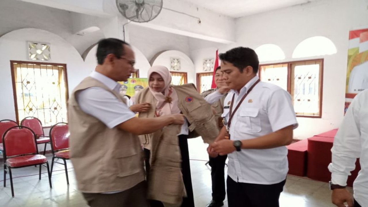 Wali Kota Mataram H Mohan Roliskana (kiri) memasangkan rompi kepada camat se-Kota Mataram, Provinsi Nusa Tenggara Barat, sebagai tanda terbentuknya desa/kelurahan tangguh bencana (Destana), Rabu (13/9-2023). (ANTARA/Nirkomala)