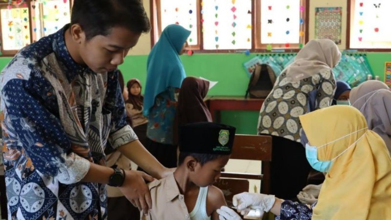 Petugas Dinas Kesehatan Kota Pekalongan sedang memberikan imunisasi pada siswa sekolah madrasah ibtidaiyah di Pekalongan, Rabu (13/9/2023). (ANTARA/Kutnadi)