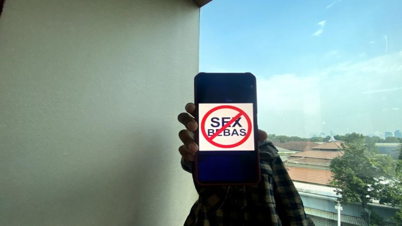 Seorang warga pada Kamis (14/09/2023), memegang flyer anti seks bebas yang dimuat di website Kemenkumham. (ANTARA/Muzdaffar Fauzan/Kemenkumham)