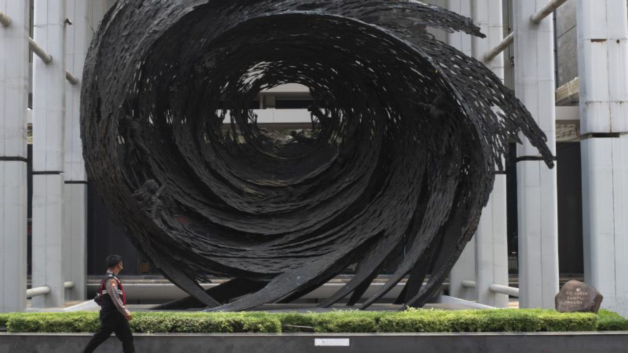 Seorang petugas kepolisian berjalan di samping patung berbentuk pusaran berjudul Ku Yakin Sampai di Sini karya Nyoman Nuarta di Museum Nasional Jakarta, Senin (18/9/2023). Operasional Museum Nasional ditutup sementara untuk proses investigasi pascakebakaran yang terjadi pada Sabtu (16/9/2023). ANTARA FOTO/Wahyu Putro A/aww
