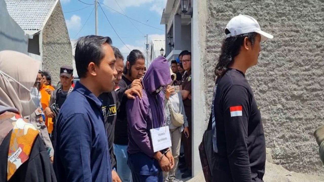 Polisi membawa tersangka saat menggelar rekaulang kasus pembunuhan seorang Dosen UIN RMS Surakarta, di rumah korban Desa Tempel, Kecamatan Gatak, Kabupaten Sukoharjo, Jawa Tengah, Selasa (12/9/2023). ANTARA/Bambang Dwi Marwoto.
