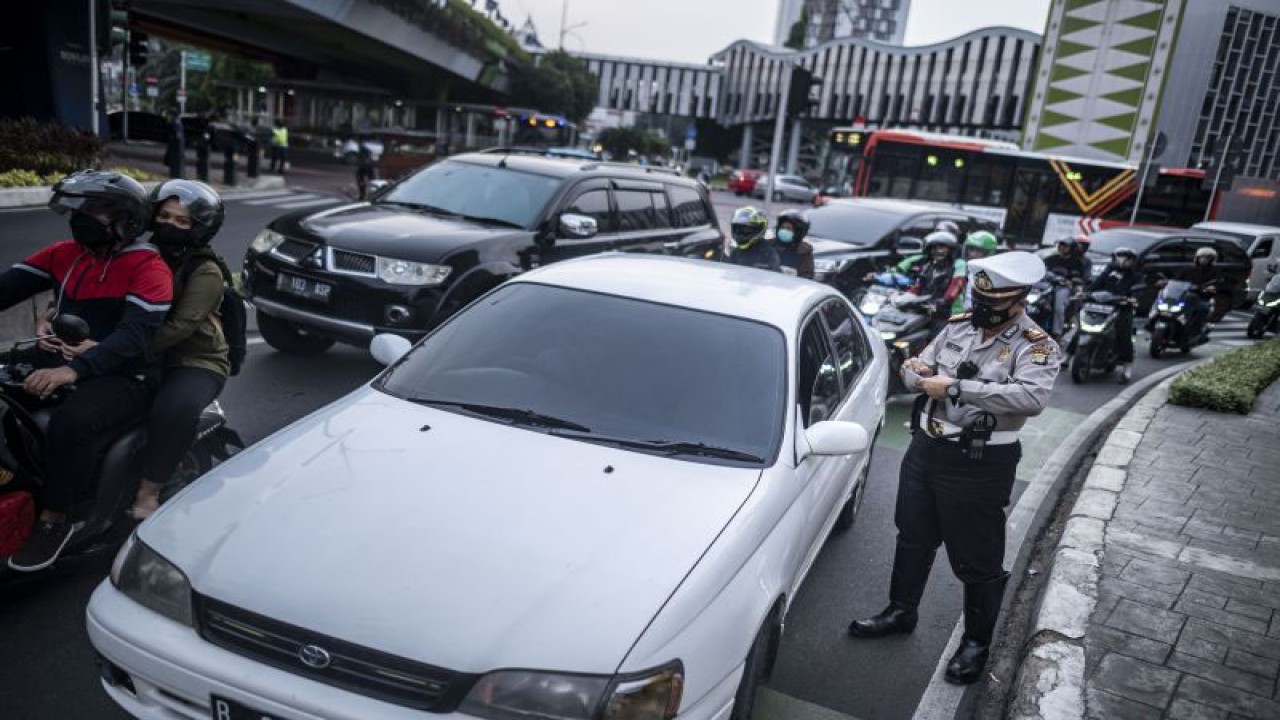 Polisi melakukan penindakan sanksi tilang kepada pengendara mobil yang menggunakan pelat nomor genap di kawasan Jalan Kramat Raya, Jakarta, Senin (13/6/2022). Ditlantas Polda Metro Jaya memberlakukan penindakan sanksi tilang terhadap pengendara yang melanggar pembatasan lalu lintas dengan sistem ganjil genap di 25 ruas jalan DKI Jakarta. ANTARA FOTO/Aprillio Akbar/tom.