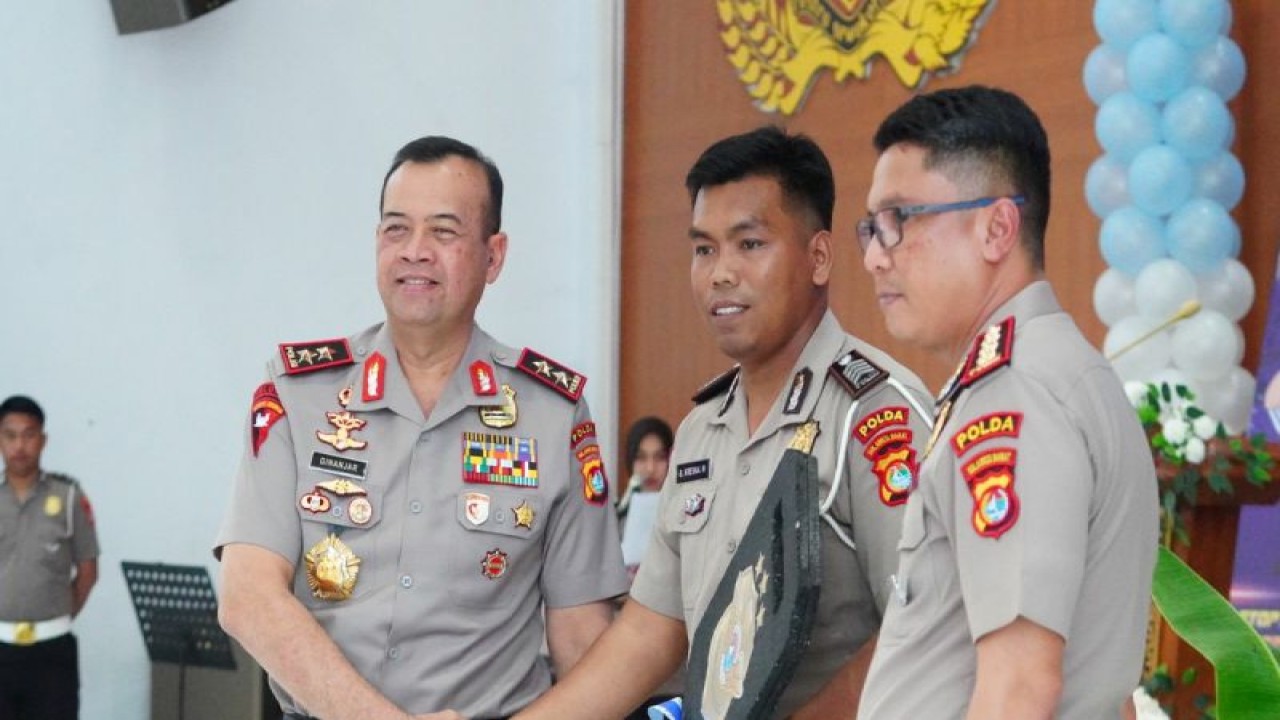 Kapolda Sulbar Inspektur Jenderal Polisi Adang Ginanjar (kiri) saat menyerahkan secara simbolis kunci kendaraan bus sekolah pada peluncuran bus sekolah, di Mamuju, Senin (25/9). ANTARA/HO/Humas Polda Sulbar.