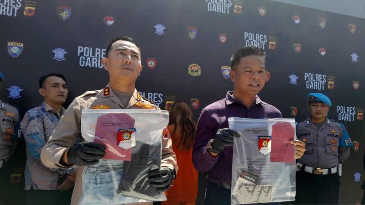 Polisi menunjukkan tersangka dan barang bukti dalam kasus video asusila saat jumpa pers di Markas Polres Garut, Jawa Barat, Jumat (29/9/2023). ANTARA/Feri Purnama.