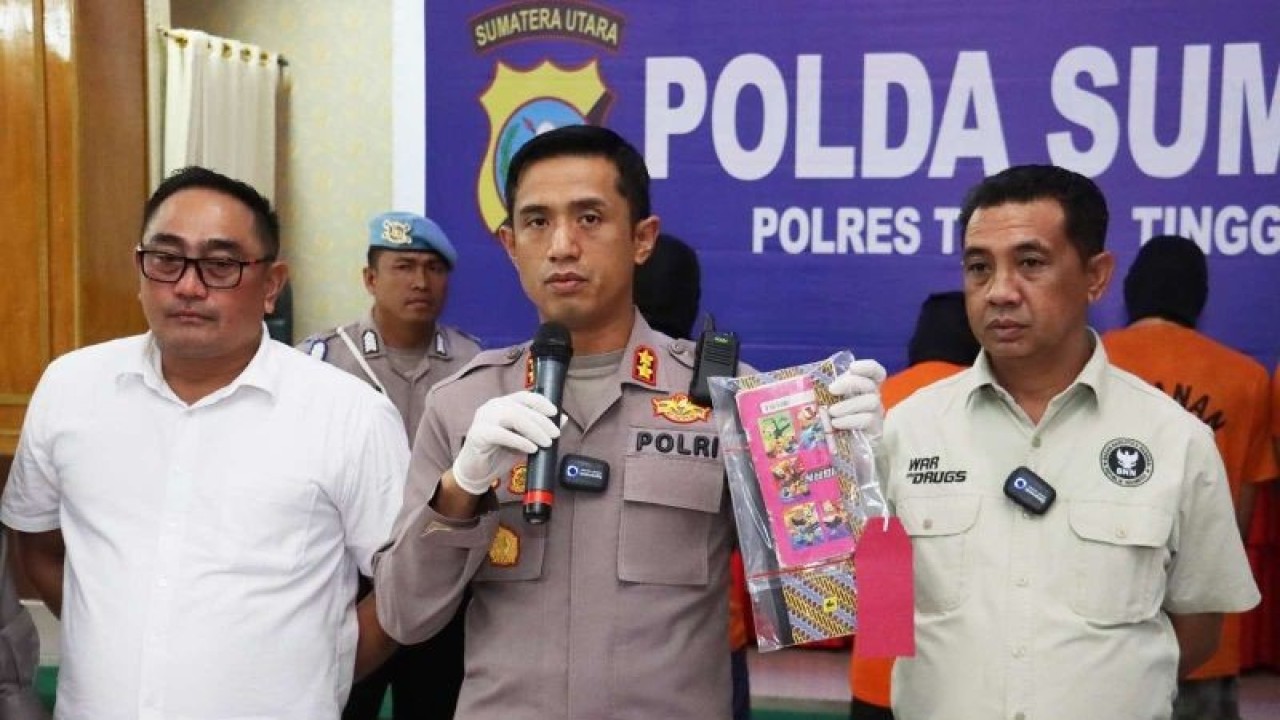 Kapolres Tebing Tinggi AKBP Andreas Tampubolon (tengah) saat menjelaskan penangkapan pelaku I (43) yang menempatkan 23 orang PMI Ilegal diberangkatkan ke Malaysia. (ANTARA /H0- Humas Polres Tebing Tinggi)