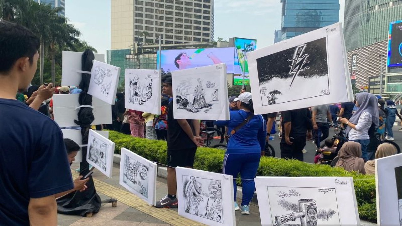 Sejumlah masyarakat menyaksikan karya karikatur yang dipamerkan dalam acara pameran karikatur pemilu di Jakarta, Minggu (24/9/2023). ANTARA/Ilham Kausar