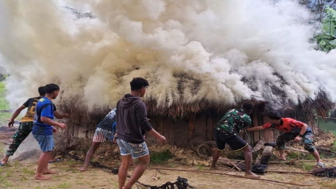 Prajurit dari Batalion Infantri 721/Makkasau membantu memadamkan api yang membakar honai atau rumah khas warga pegunungan di Kampung Tami, Distrik Balingga, Kabupaten Lanny Jaya, Papua Pegunungan. ANTARA/HO/Penerangan Kodam XVII/Cenderawasih