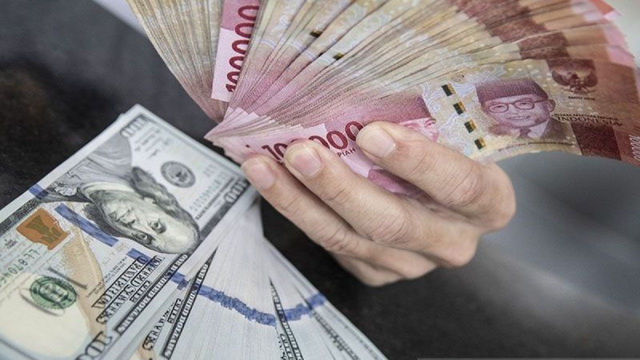 Ilustrasi - Petugas menunjukan uang pecahan rupiah dan dolar AS di gerai penukaran mata uang asing di Jakarta. (ANTARA FOTO/Muhammad Adimaja/foc/pri.)