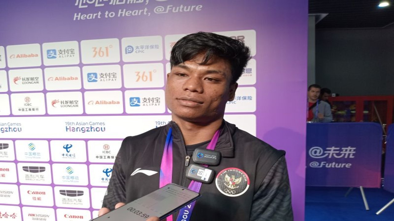 Atlet wushu Indonesia Samuel Marbun menjawab pertanyaan pewarta di mixed zone Xiaoshan Guali Sports Centre, Hangzhou, Kamis (28/9/2023). (ANTARA/RAUF ADIPATI)