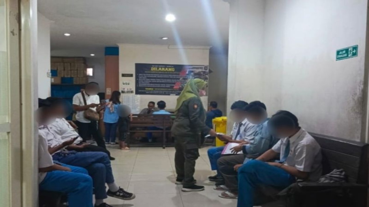 Petugas Satpol PP mendata pelajar sekolah menengah atas yang pada jam sekolah kedapatan nongkrong di kawasan Jalan Pucang Jajar, Kertajaya, Gubeng, Surabaya, Jawa Timur, Selasa (19/2023). (ANTARA/HO-Diskominfo Surabaya)