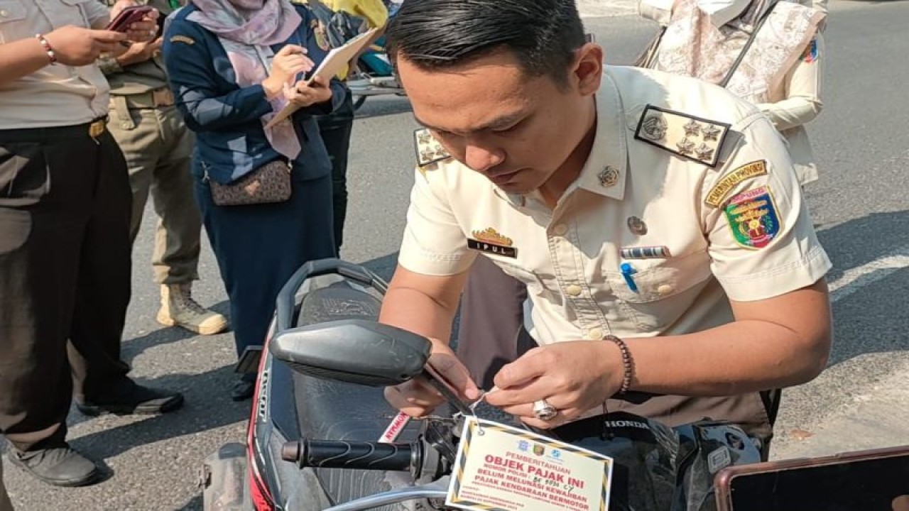 Pemasangan stiker pemberitahuan menunggak pajak bagi penunggak pajak kendaraan bermotor. ANTARA/Ruth Intan Sozometa Kanafi