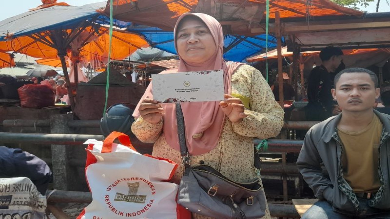 Nurhayati salah seorang pedagang bontot di Pasar Keranggot, Cilegon, Banten, menerima bantuan dari Presiden Jokowi, Selasa (12/9/2023). (ANTARA/Desi Purnama Sari)