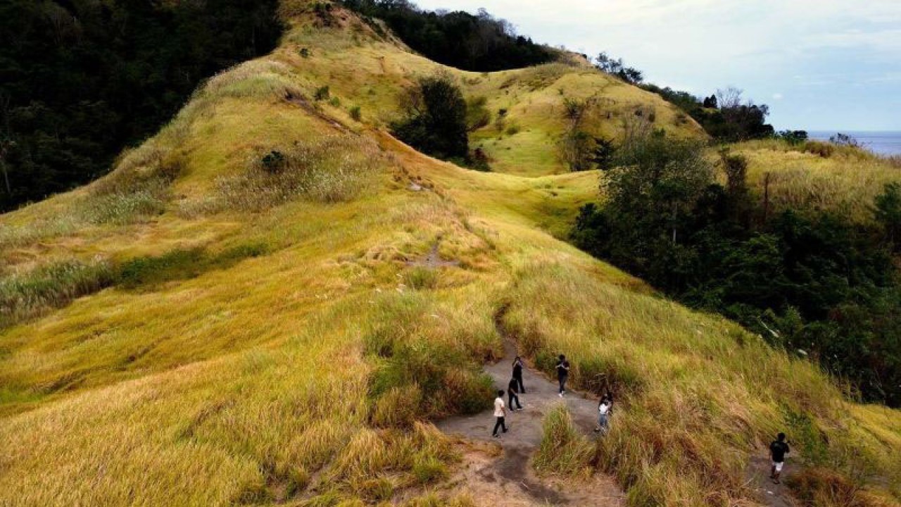Beberapa wisatawan mengunjungi obyek wisata alam Bukit Larata di Desa Kinunang, Likupang Timur, Minahasa Utara, Sulawesi Utara, Jumat (15/9/2023). Obyek wisata yang dikelola oleh masyarakat melalui Badan Usaha milik Desa (BUMDES) itu diharapkan dapat membawa pemasukan bagi desa seiring dengan adanya Kawasan Ekonomi Khusus (KEK) Pariwisata Likupang seluas 197,4 hektar yang mencakup tiga desa. ANTARA FOTO/Adwit B Pramono/aww.