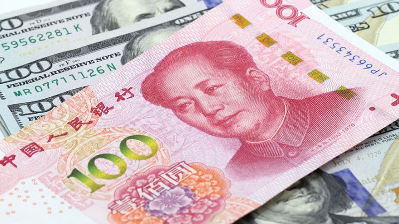 Ilustrasi - 100 yuan China di atas uang dolar AS. ANTARA/Shutterstock/pri.