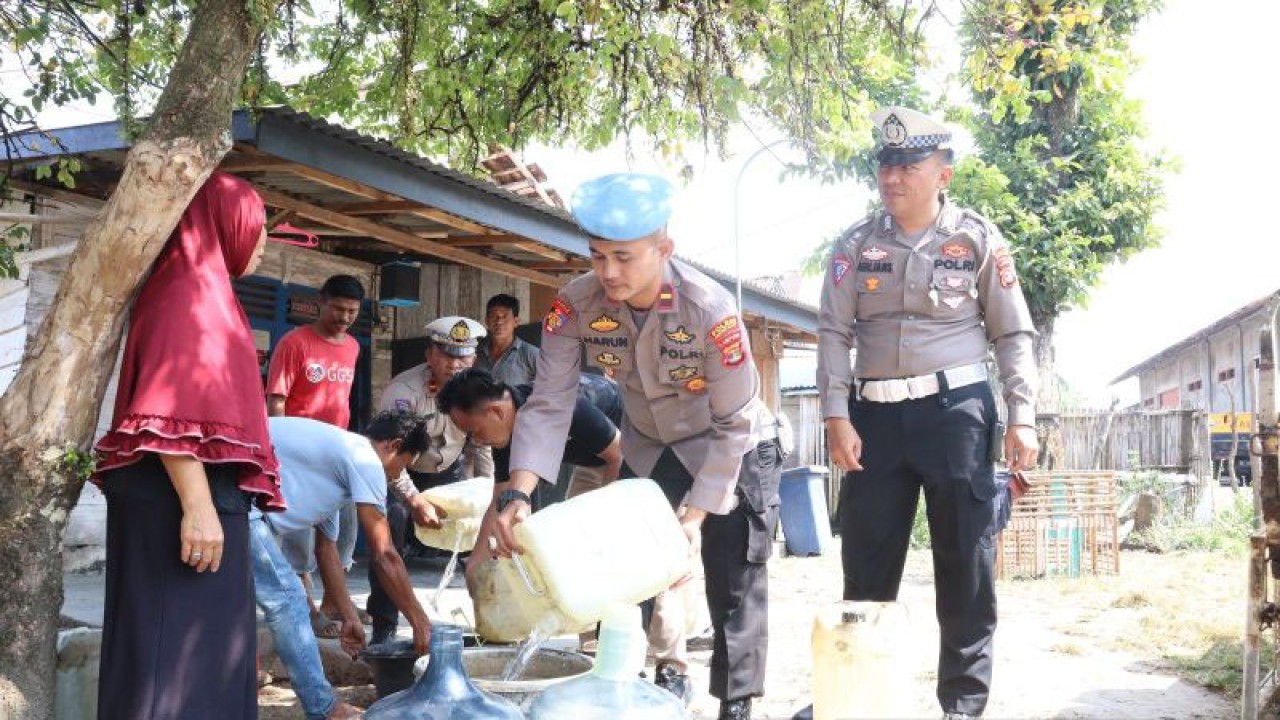 Suasana personel kepolisian saat membagikan air bersih untuk warga (ANTARA/Riadi Gunawan).