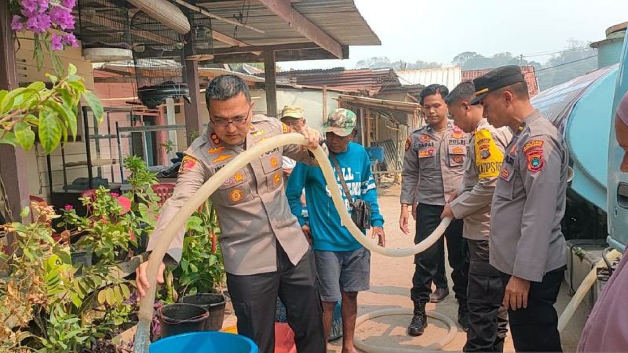 Kapolres Bangka Barat AKBP Ade Zamrah membantu petugas menyalurkan bantuan air bersih kepada warga di Kampung Tanjung, Kecamatan Mentok, Rabu (4/10/2023). ANTARA/Donatus Dasapurna