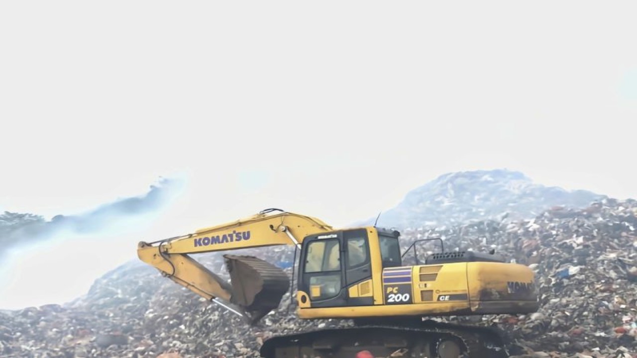 Alat berat yang digunakan dalam upaya memadamkan api di lapisan bawah tumpukan sampah di TPA Bakung yang terbakar sejak Jumat (13/10). Bandarlampung, Senin, (16/10/2023). (ANTARA/Dian Hadiyatna)