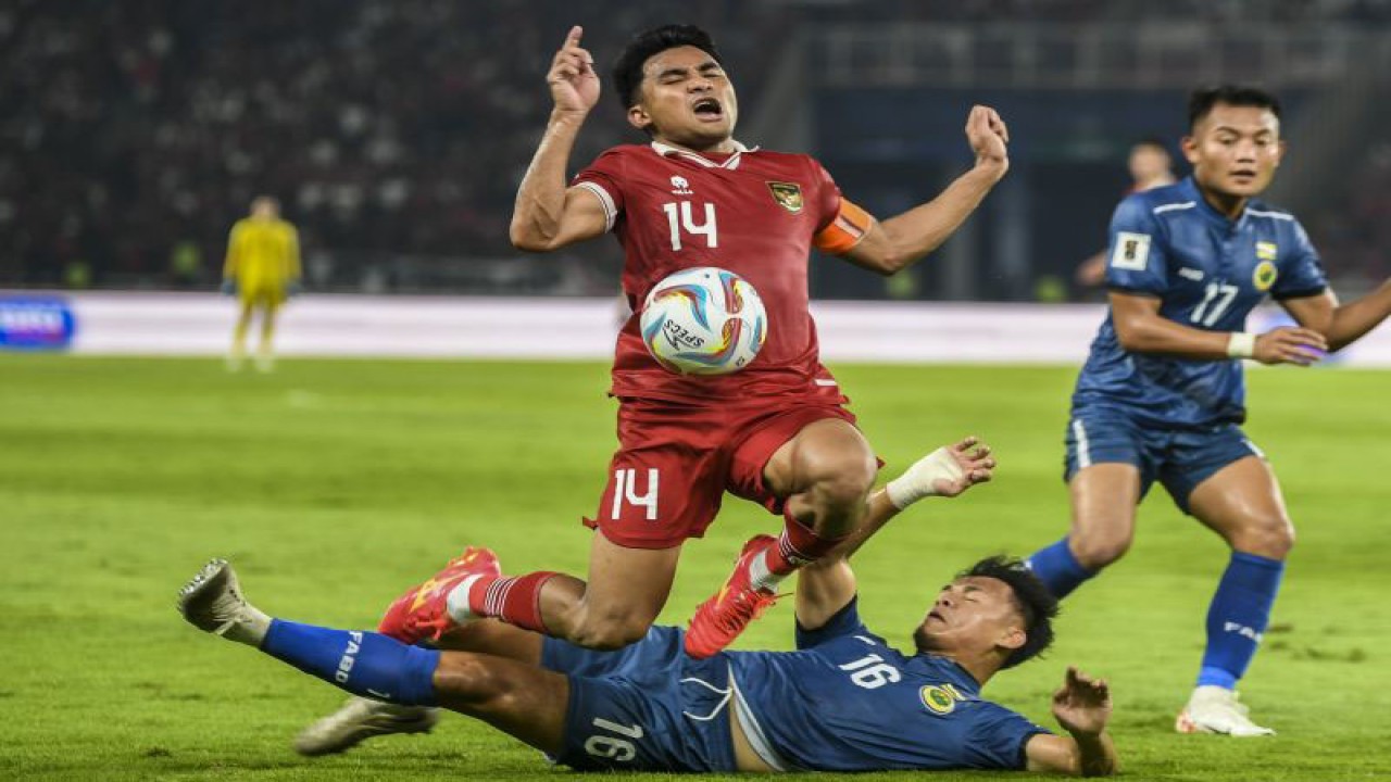 Pesepak bola timnas Indonesia Asnawi Mangkualam (atas) berusaha melewati hadangan pesepak bola timnas Brunei Mohammad Hirzi (bawah) dalam pertandingan leg 1 kualifikasi Piala Dunia 2026 babak pertama zona Asia di Stadion Utama Gelora Bung Karno (GBK), Senayan, Jakarta, Kamis (12/10/2023). Indonesia menang atas Brunei dengan skor 6-0. ANTARA FOTO/Galih Pradipta/Spt.