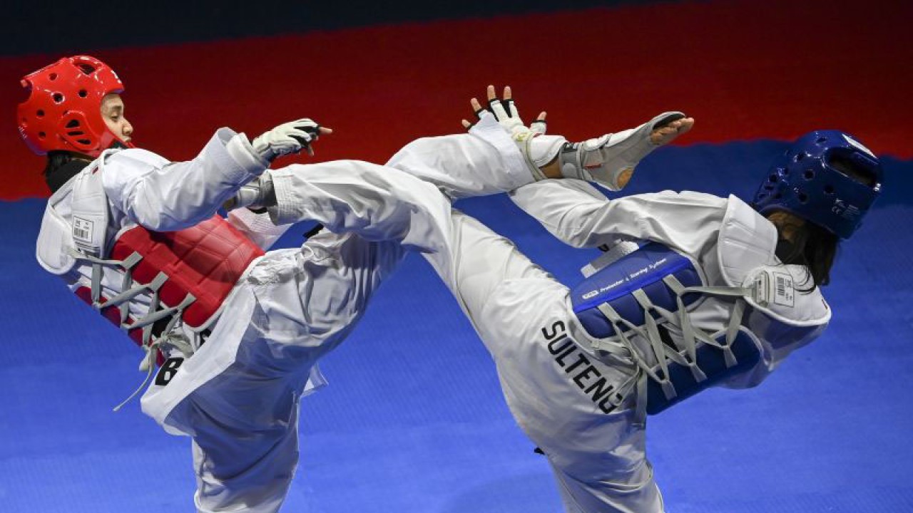 Atlet taekwondo putri Jawa Barat Megawati Tamesti Maheswari (kiri) dan atlet taekwondo putri Sulawesi Tengah Firilia Dinisa (kanan) saling melepaskan tendangan saat pertandingan final Taekwondo kategori Kyorugi kelas U 49 Kg putri PON Papua di GOR Politeknik Penerbangan Kayu Batu, Kota Jayapura, Papua, Senin (4/10/2021). ANTARA FOTO/Nova Wahyudi/wsj. (ANTARA FOTO/NOVA WAHYUDI)