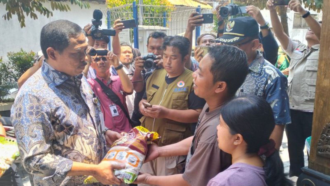 Penjabat (Pj) Gubernur Jawa Tengah Nana Sudjana menyerahkan bantuan kepada para pengungsi di Solo, Jawa Tengah, Rabu (4/10/2023). ANTARA/Aris Wasita