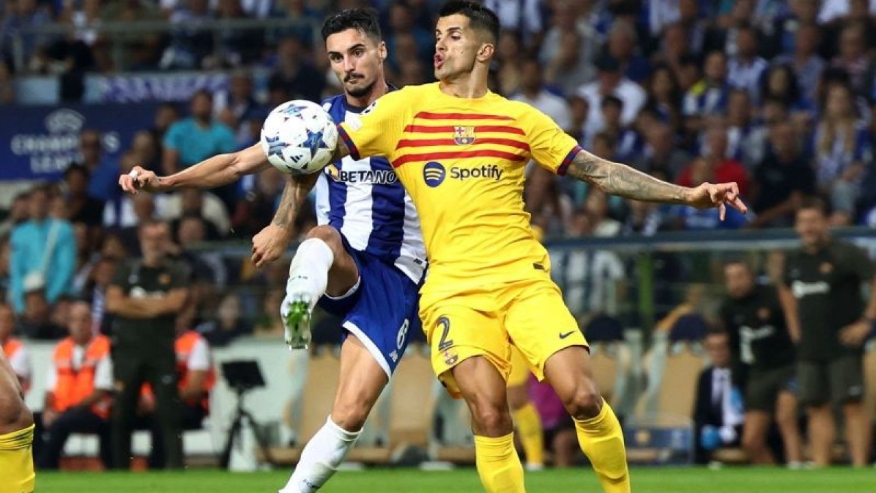Pemain FC Barcelona Joao Cancelo berebut bola dengan pemain FC Porto Stephen Eustaquio pada laga Grup H Liga Champions melawan Barcelona di Estadio do Dragao, Porto, Portugal (4/10/2023). Barcelona berhasil petik kemenangan 1-0 di kandang FC Porto melalui gol tunggal Ferran Torres pada menit ke-45+1. ANTARA FOTO/REUTERS/Pedro Nunes/aww.