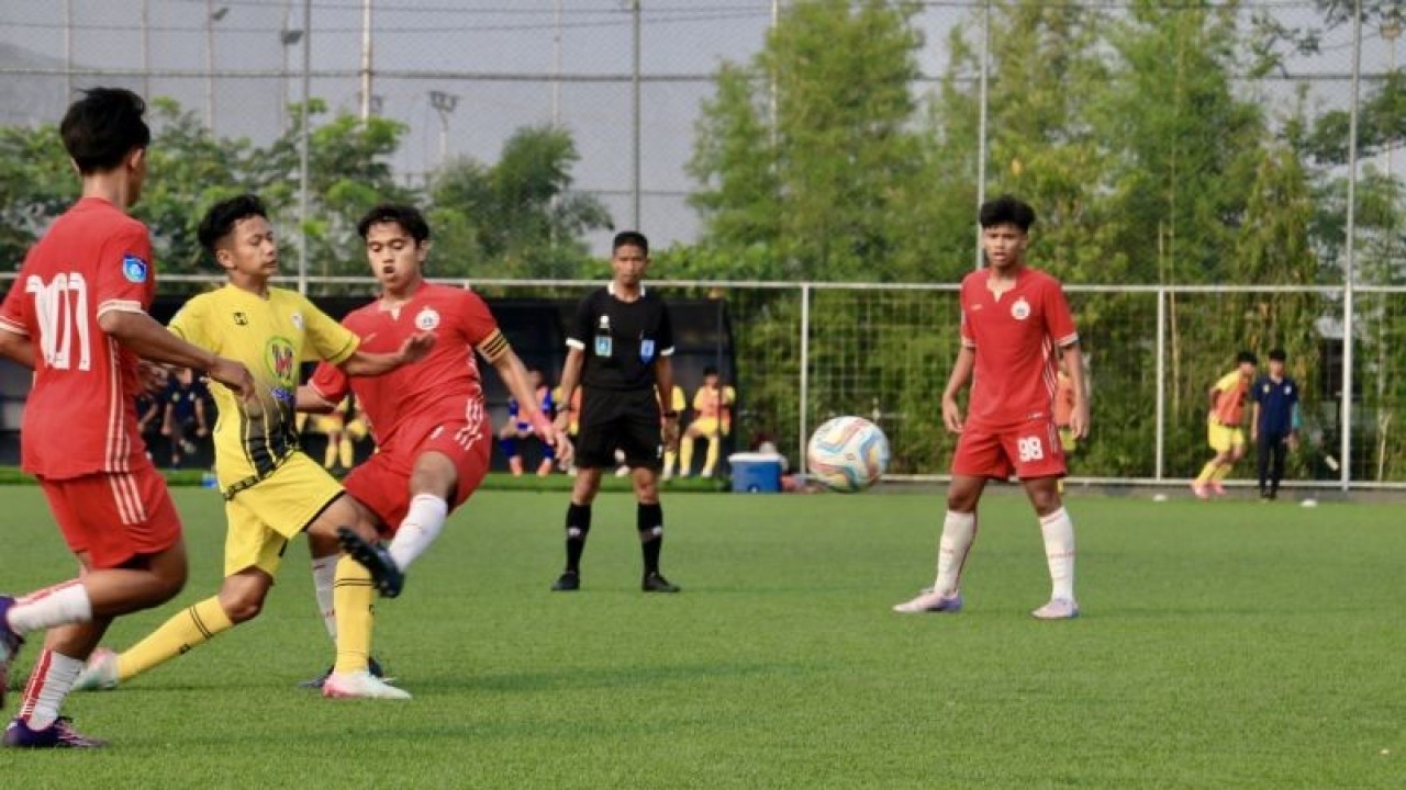 Pemain Barito Putera U-16 (kuning) berusaha melewati pemain belakang Persija Jakarta U-16 (merah), di Green Yakin Soccer Field Banjarmasin, Kalimantan Selatan, Minggu (8/10/2023). (ANTARA/Tumpal Andani Aritonang)