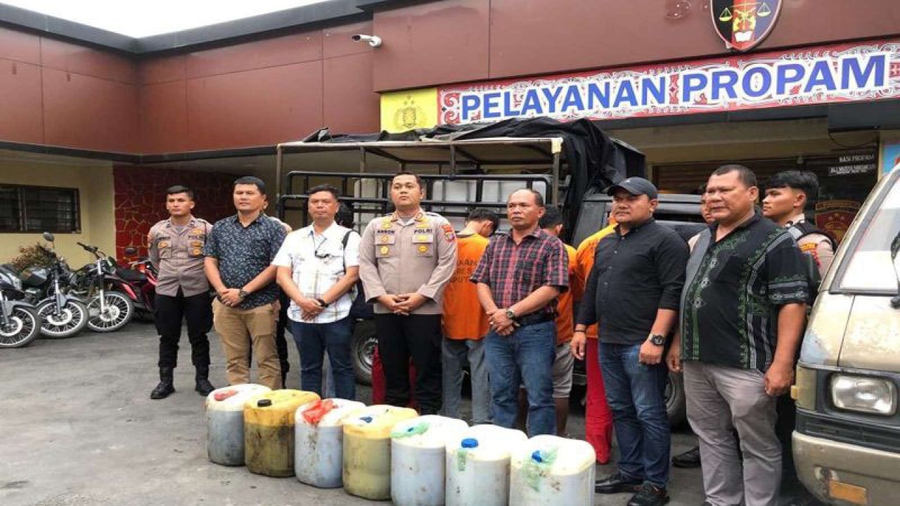 Kapolres Taput AKBP Johanson Sianturi (tengah) dan barang bukti bahan bakar minyak (BBM) bersubsidi jenis bio solar. ((ANTARA /H0- Humas Polres Taput).)