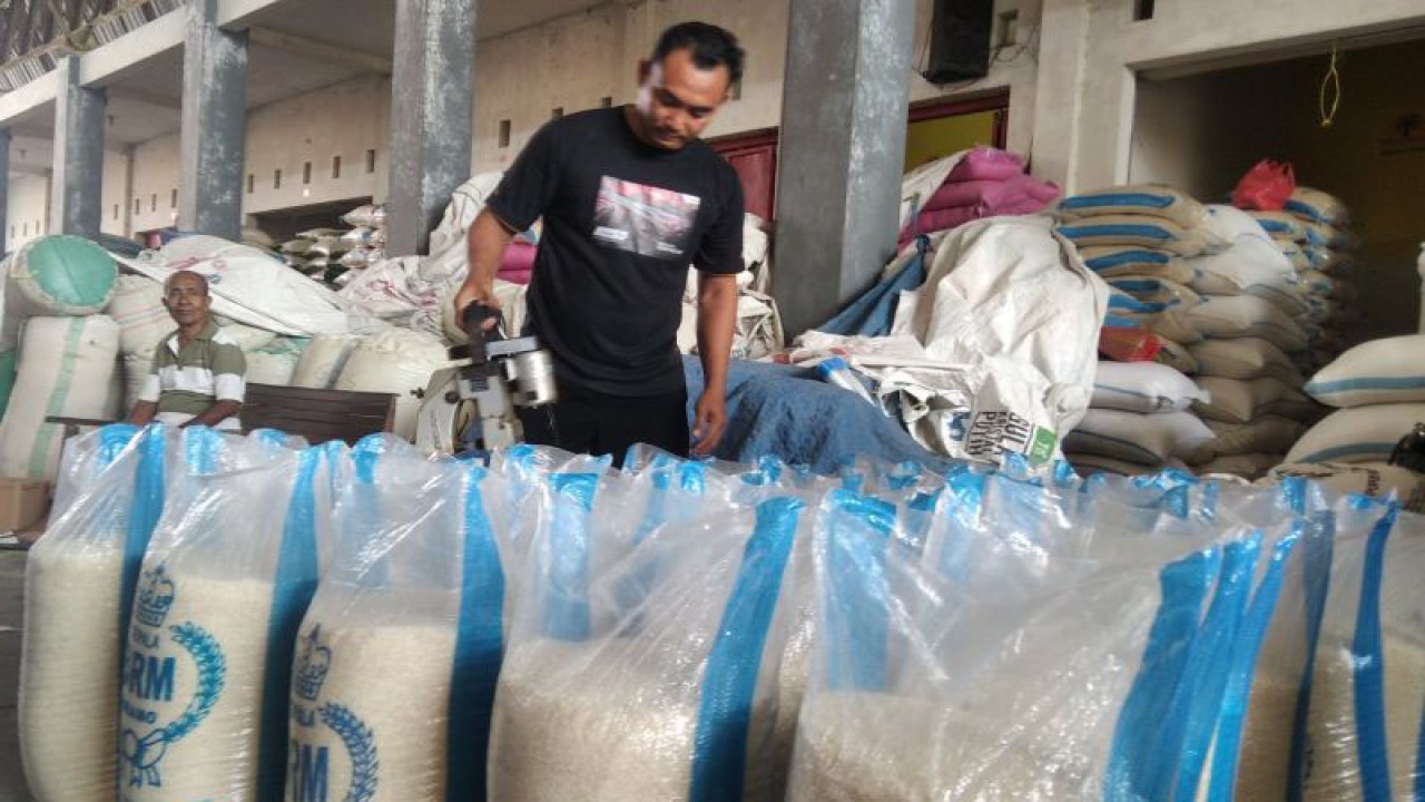 Seorang pedagang beras di Pasar Baru Kudus, Jawa Tengah, tengah mengemasi berasnya ke dalam karung plastik. (ANTARA/Akhmad Nazaruddin Lathif)