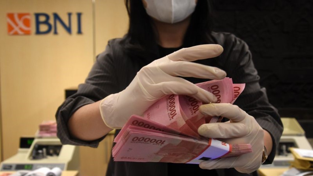 Seorang karyawan menghitung uang nasabah di Kantor Cabang BNI Jakarta Pusat, Jumat (27/5/2022). ANTARA FOTO/Indrianto Eko Suwarso/tom.