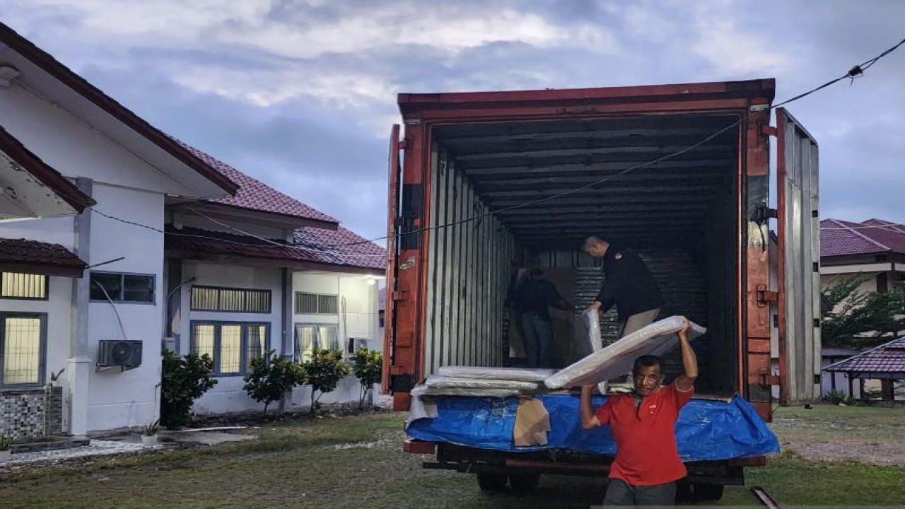 Pekerja menurunkan bilik suara dari dalam mobil box yang tiba di Kantor KIP Abdya, di Blangpidie, Kabupaten Aceh Barat Daya, Minggu (15/10/2023). (ANTARA/HO-KIP Abdya)