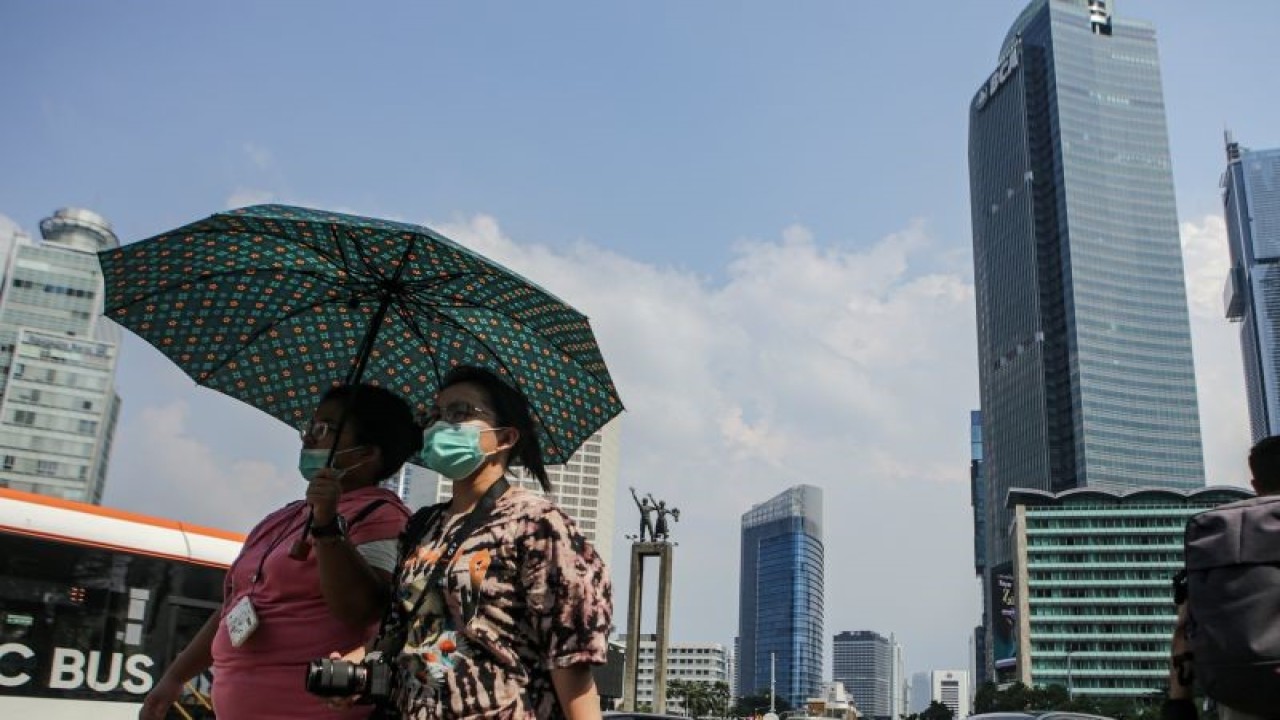 Warga berjalan di tengah cuaca terik di kawasan Bundaran HI, Jakarta, Senin (24/4/2023). Badan Meteorologi Klimatologi dan Geofisika (BMKG) menyampaikan dinamika atmosfer yang tidak biasa menjadi salah satu penyebab Indonesia mengalami suhu panas dalam beberapa hari terakhir. ANTARA FOTO/Fauzan/aww. (ANTARA FOTO/FAUZAN)