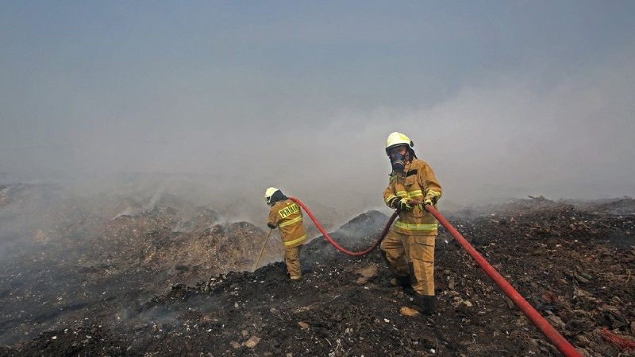 Petugas pemadam kebakaran melakukan pendinginan gunungan sampah yang terbakar di tempat pembuangan akhir (TPA) Rawa Kucing, Neglasari, Kota Tangerang, Banten, Minggu (22/10/2023). Setelah terbakar hampir tiga hari, akhirnya api yang membakar sampah seluas 35 hektar itu dapat dipadamkan petugas. ANTARA FOTO/Muhammad Iqbal/Spt.
