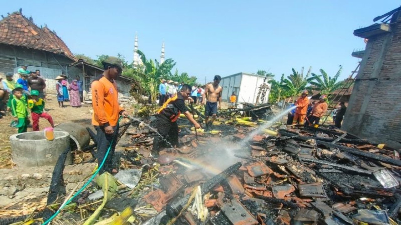 Tim pemadam kebakaran melakukan pemadaman bara api yang sebelumnya membakar satu rumah hingga ludes, sedangkan rumah di sebelahnya hanya terbakar bagian atap bangunannya. (ANTARA/HO-Bpbd Kudus.)