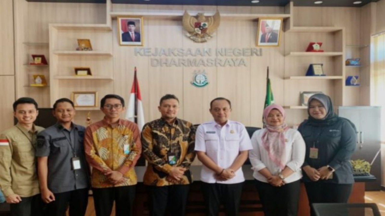 Kepala BPJS Ketenagakerjaan Cabang Dharmasraya Arif Dharmamawan (tiga kiri) dan Kepala Kejari Dharmasraya Dodik Hermawan foto bersama usai menyerahkan SKK di Kantor Kejari setempat, Senin (9/10). (Antara/HO-BPJS Ketenagakerjaan)