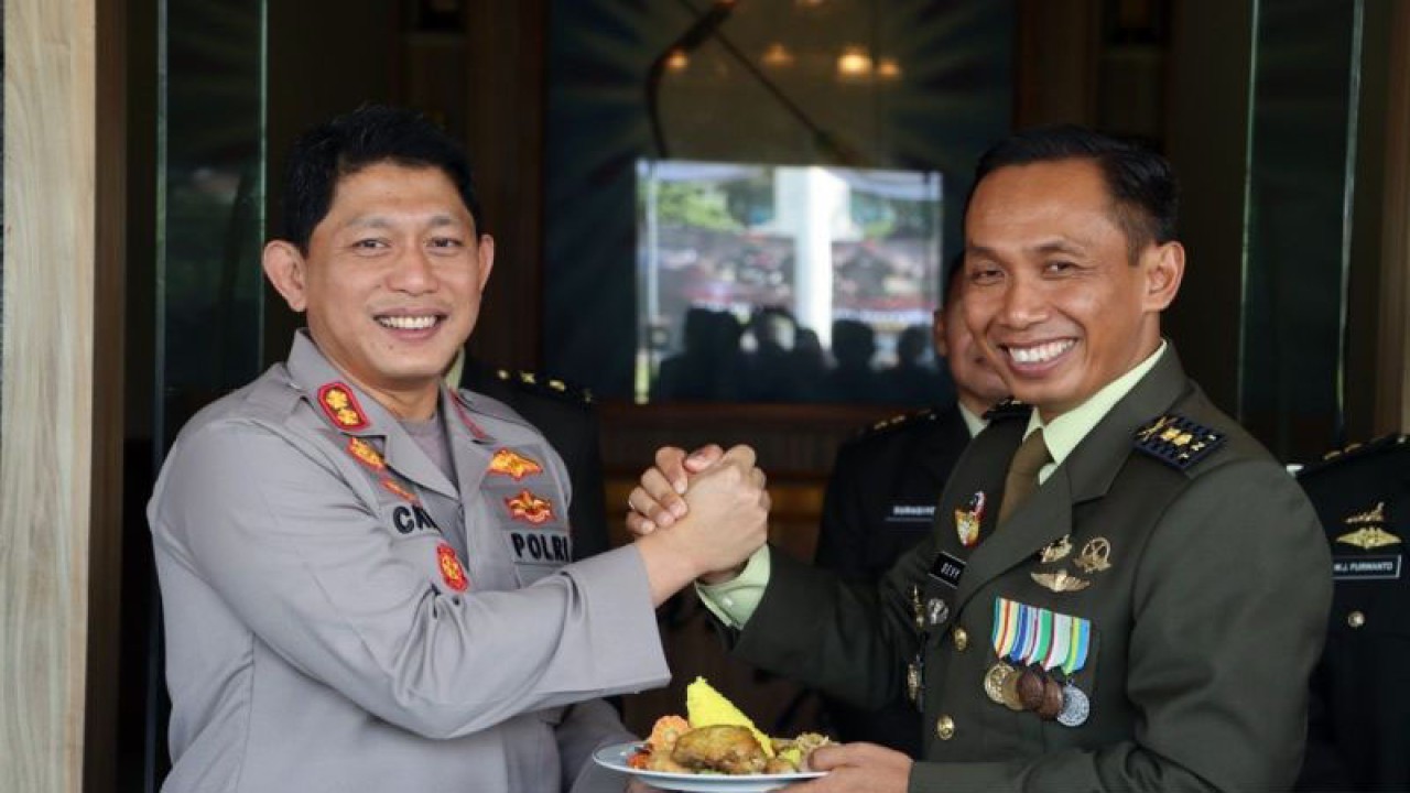 Kasrem 074/ Warastratama Letkol. Inf. Devy Kristiono (kanan), serahkan tumpeng kepada Wakapolresta Surakarta AKBP Catur Cahyono Wibowo di Markas Korem 074/Warastratama di Solo, Jawa Tengah, Kamis (5/10/2023). ANTARA/Bambang Dwi Marwoto.