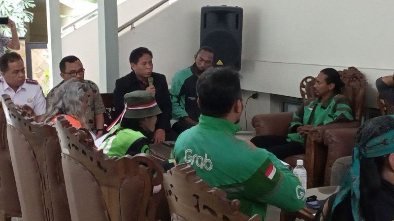 Ketua Komisi II DPRD Kabupaten Banyumas Subagyo (memegang mikrofon) dan Kepala Dinhub Kabupaten Banyumas Agus Sriyono (kiri) menerima 10 orang perwakilan pengemudi ojol untuk beraudiensi di Gedung DPRD Kabupaten Banyumas, Jawa Tengah, Selasa (3/10/2023). ANTARA/Sumarwoto