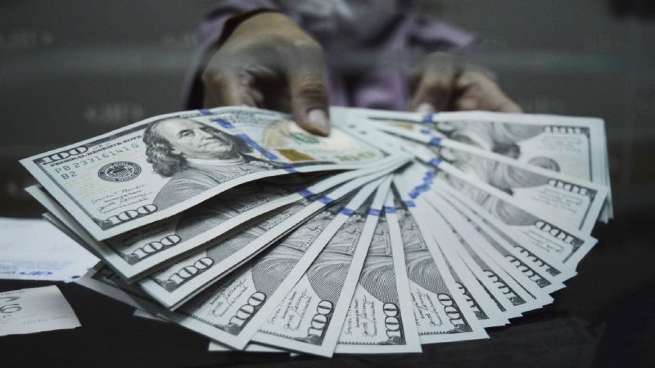 Petugas menunjukkan uang dolar AS di salah satu gerai penukaran uang asing di Jakarta, Selasa (10/10/2023). ANTARA FOTO/Bagus Ahmad Rizaldi/sgd/Y