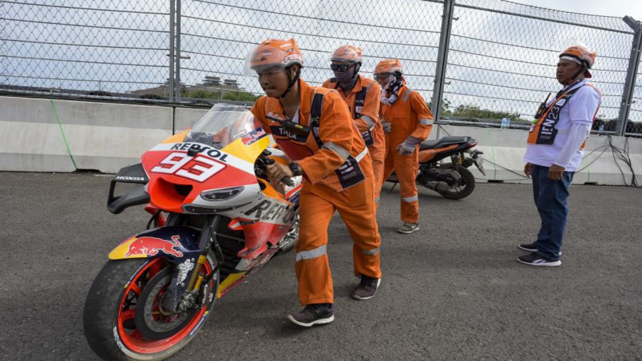 Sejumlah marshal mendorong motor pembalap Repsol Honda Team MotoGP Marc Marquez yang terjatuh saat balapan MotoGP seri Pertamina Grand Prix of Indonesia 2023 di Pertamina Mandalika International Street Circuit, Lombok Tengah, NTB, Minggu (15/10/2023). Francesco Bagnaia berhasil menjadi juara pertama diikuti Pembalap Aprilia Racing Maverick Vinales diposisi kedua dan Pembalap Monster Energy Yamaha Fabio Quartararo diposisi ketiga.ANTARA FOTO/Ahmad Subaidi/nz (ANTARA FOTO/AHMAD SUBAIDI)