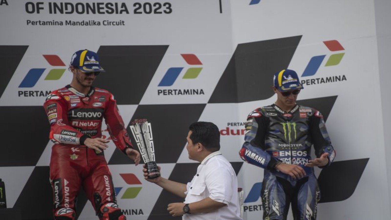 Menko Marves Ad-interim Erick Thohir (tengah) memberikan trofi juara pertama ke pembalap Ducati Lenovo Team Francesco Bagnaia disaksikan juara ketiga pembalap Monster Energy Yamaha Fabio Quartararo.seusai balapan MotoGP seri ke-15 di Pertamina Mandalika International Street Circuit, Lombok Tengah, NTB, Minggu (15/10/2023). Francesco Bagnaia menjuarai MotoGP Mandalika setelah menyelesaikan 27 lap dengan catatan waktu 41 menit 20,293 detik disusul pembalap Aprilia Racing Maverick Vinales dan pembalap Monster Energy Yamaha Fabio Quartararo. ANTARA FOTO/Wahyu Putro A/nz
